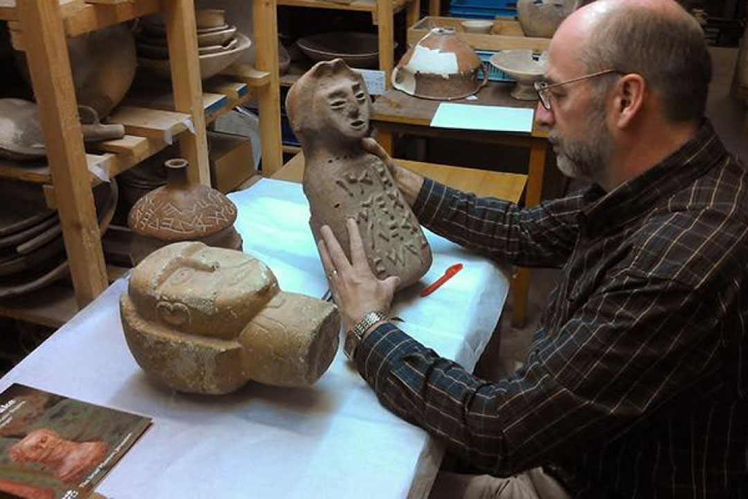 Christopher Rollston holds a pot inscribed with modern forgery at the Rockefeller Museum in Jerusalem.