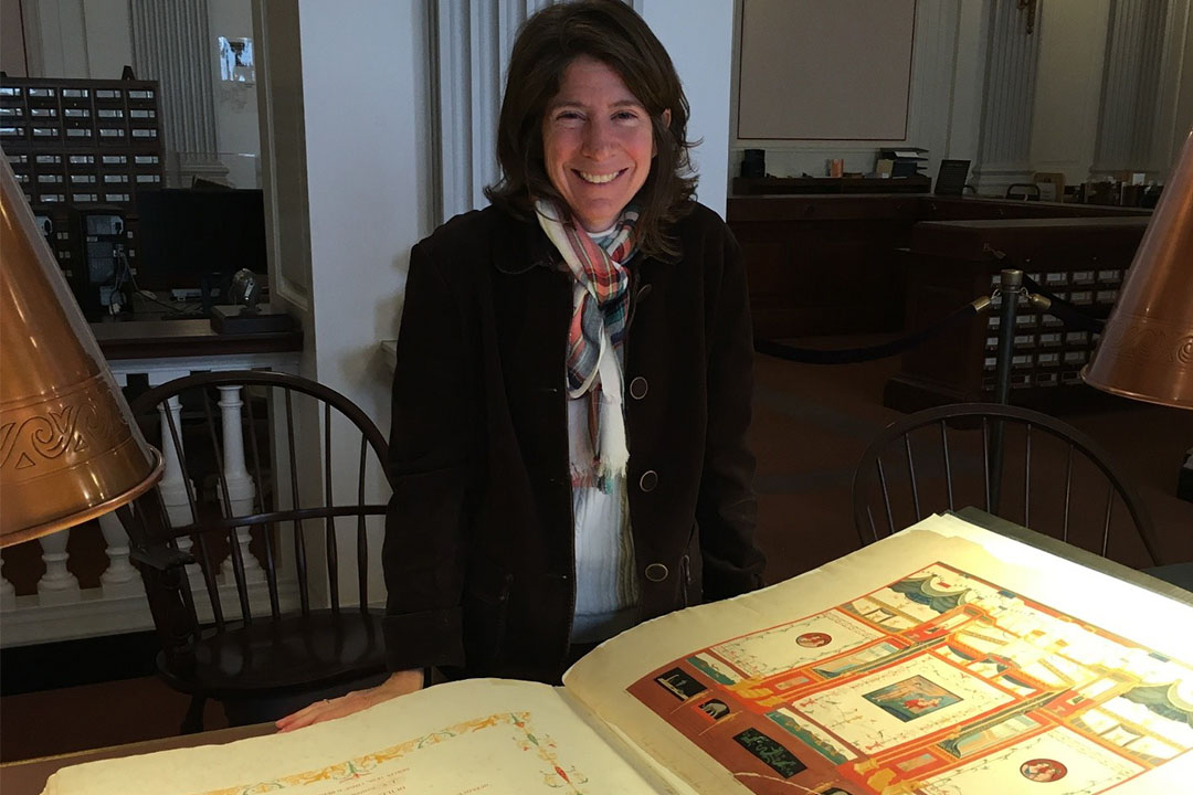 Elise Friedland standing in front of a huge, old book in the Library of Congress
