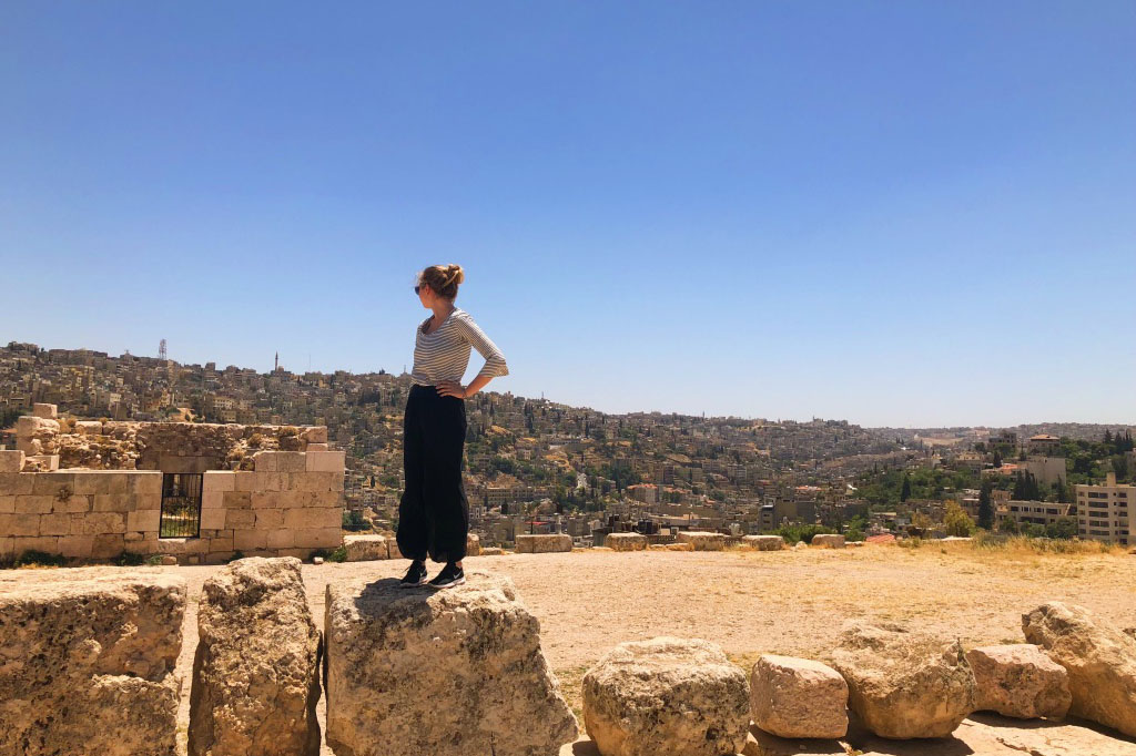 Maggie Thielens under a blue sky by some ruins